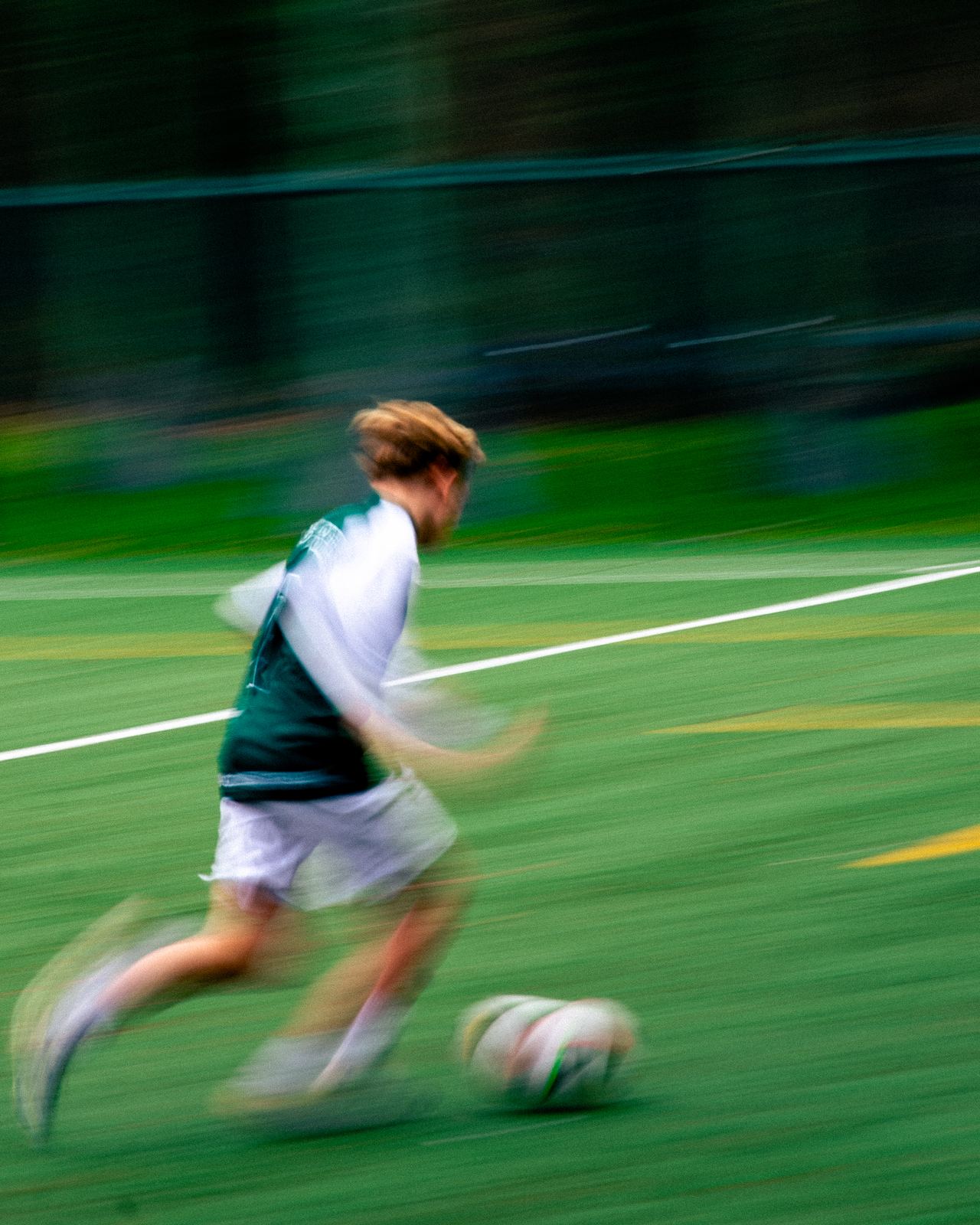 Speler sprint met de bal, bewogen achtergrond