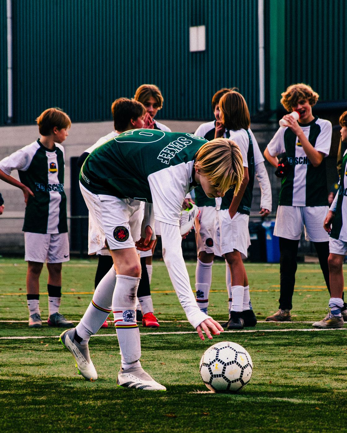 Speler raapt de bal op voor de aftrap